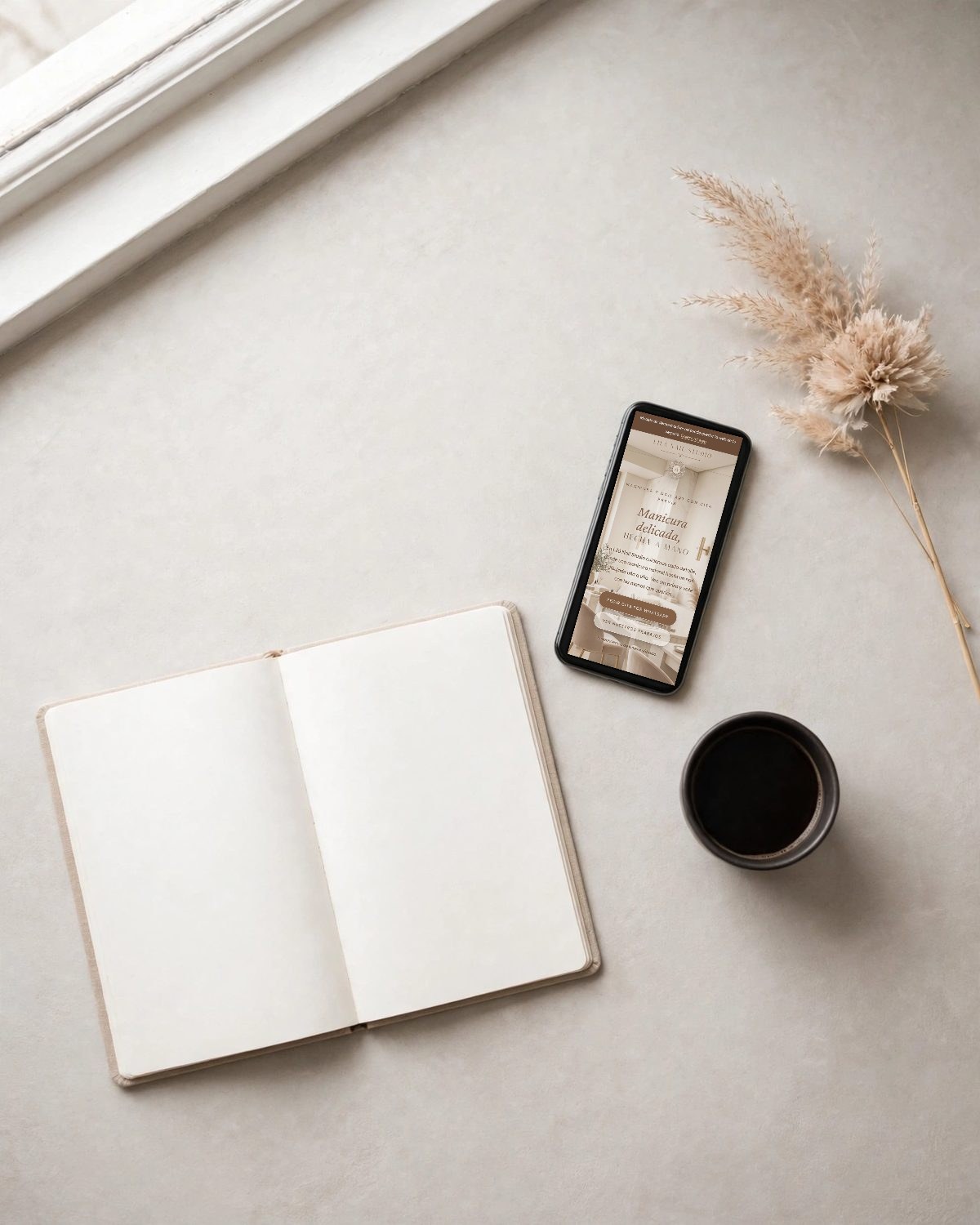Libreta, móvil con la web modelo de uñas y taza de café